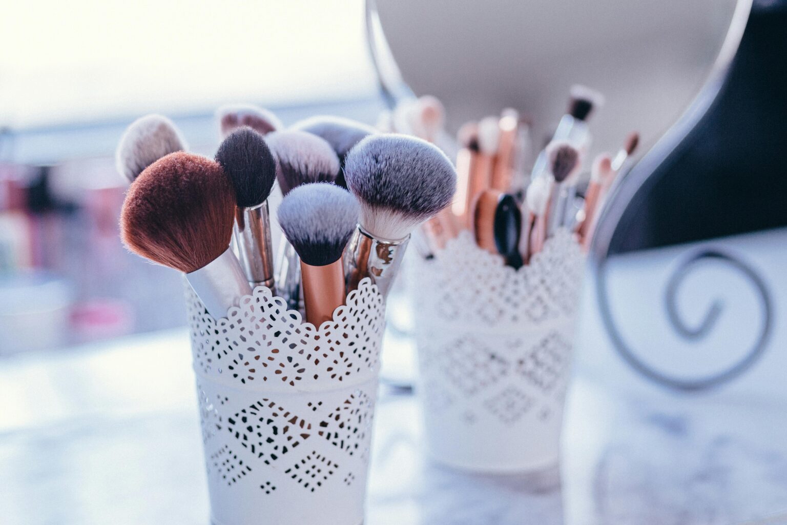 A collection of makeup brushes in decorative holders, ideal for beauty and fashion themes.