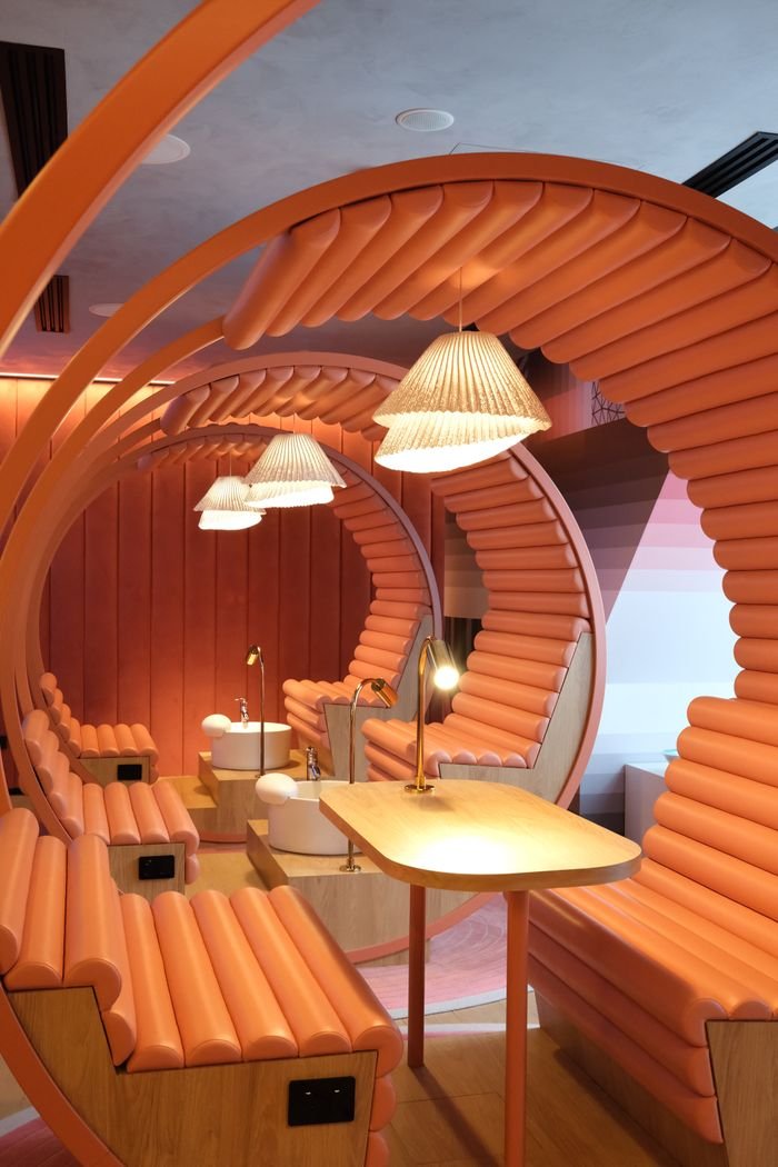 Stylish office interior with unique curved seating and decorative lighting.