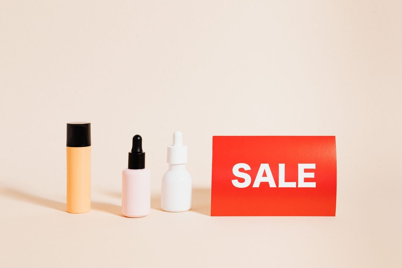 beauty salon marketing - Three skincare bottles with a red sale sign, perfect for shopping promotions.
