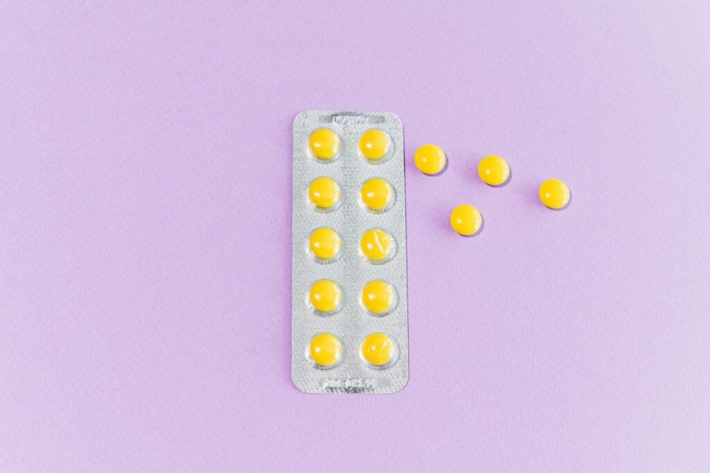folic acid - Close-up of yellow pills in blister pack on purple surface, emphasizing modern healthcare.