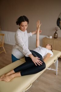 mummys physio - Physiotherapist aids woman with therapeutic exercises indoors.